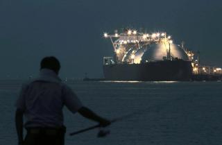 LNG tanker ship with a person fishing the foreground.